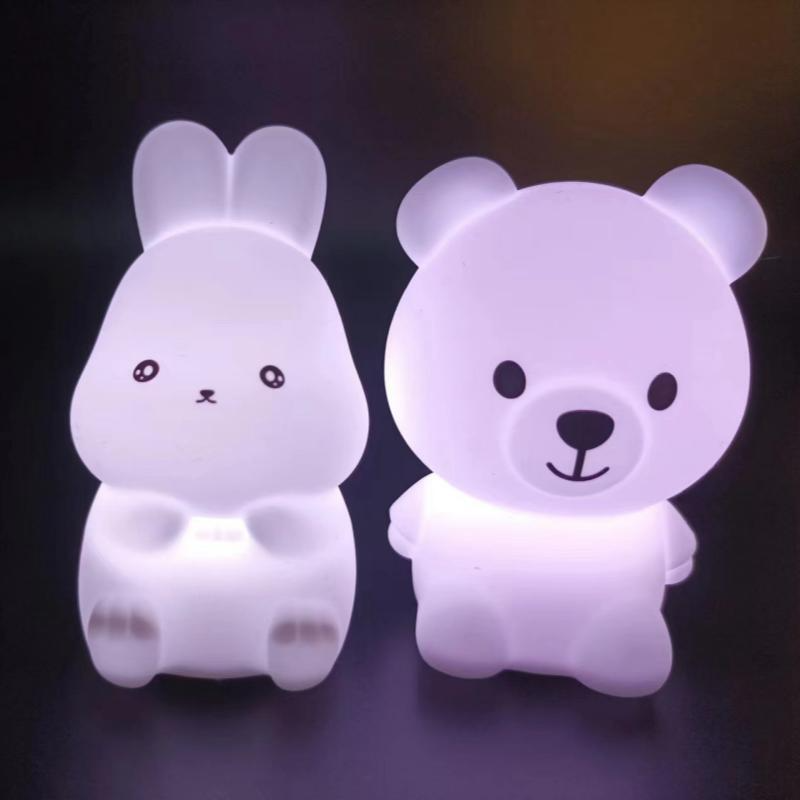Two cartoon animal night lights, one shaped like a rabbit and the other like a bear, on a dark background.