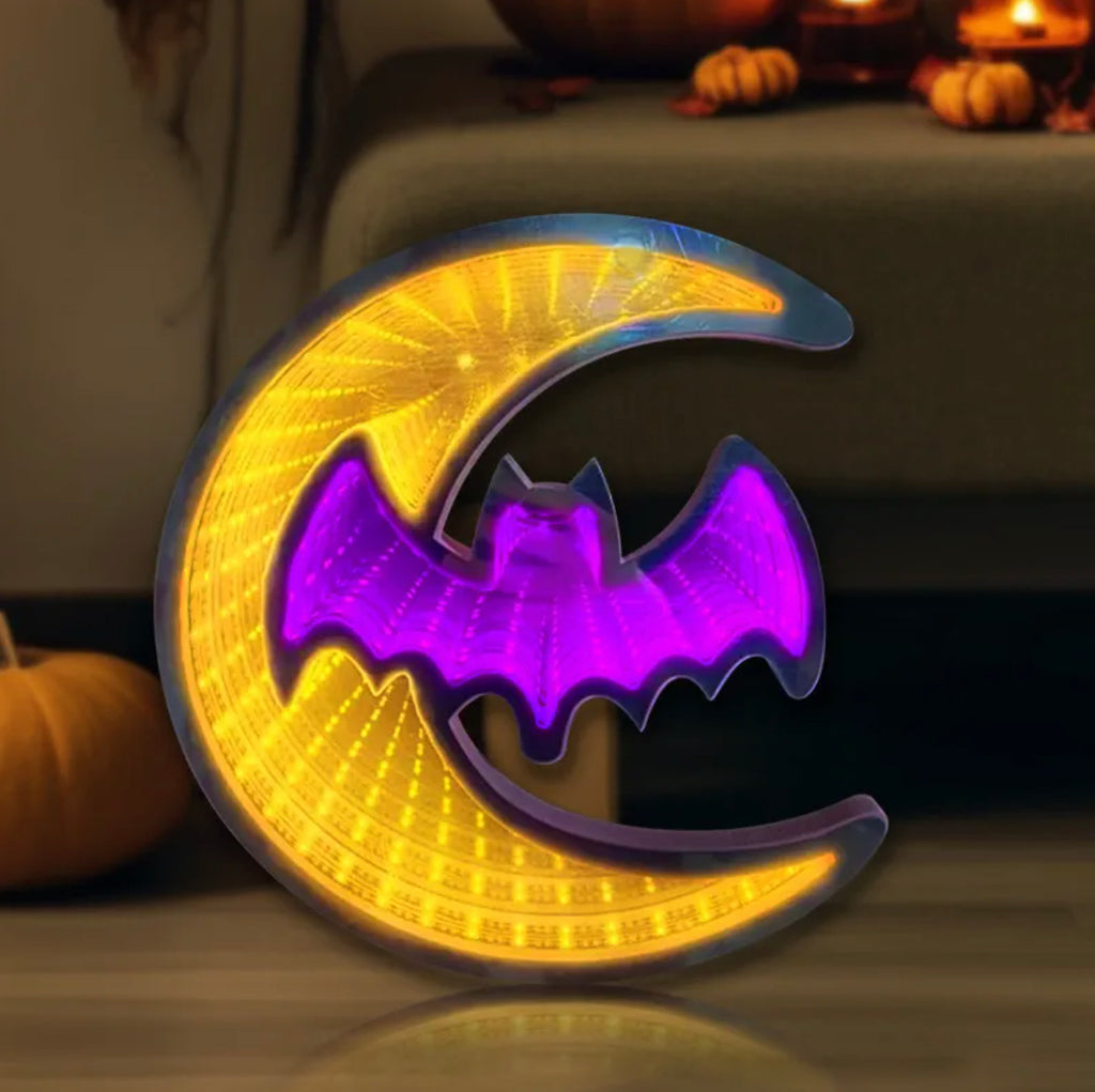 Decorative Halloween light with a bat on a moon, glowing in a dark setting.
