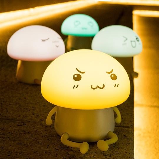 Cute mushroom-shaped night light with a smiling face on a wooden surface.