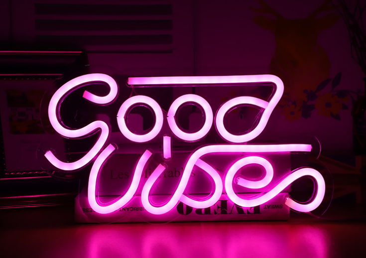 Neon sign with 'Good Vibes' text on a dark background