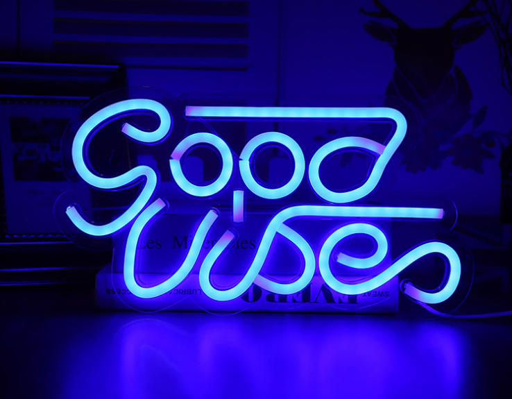 Neon sign with 'Good Vibes' text on a dark background