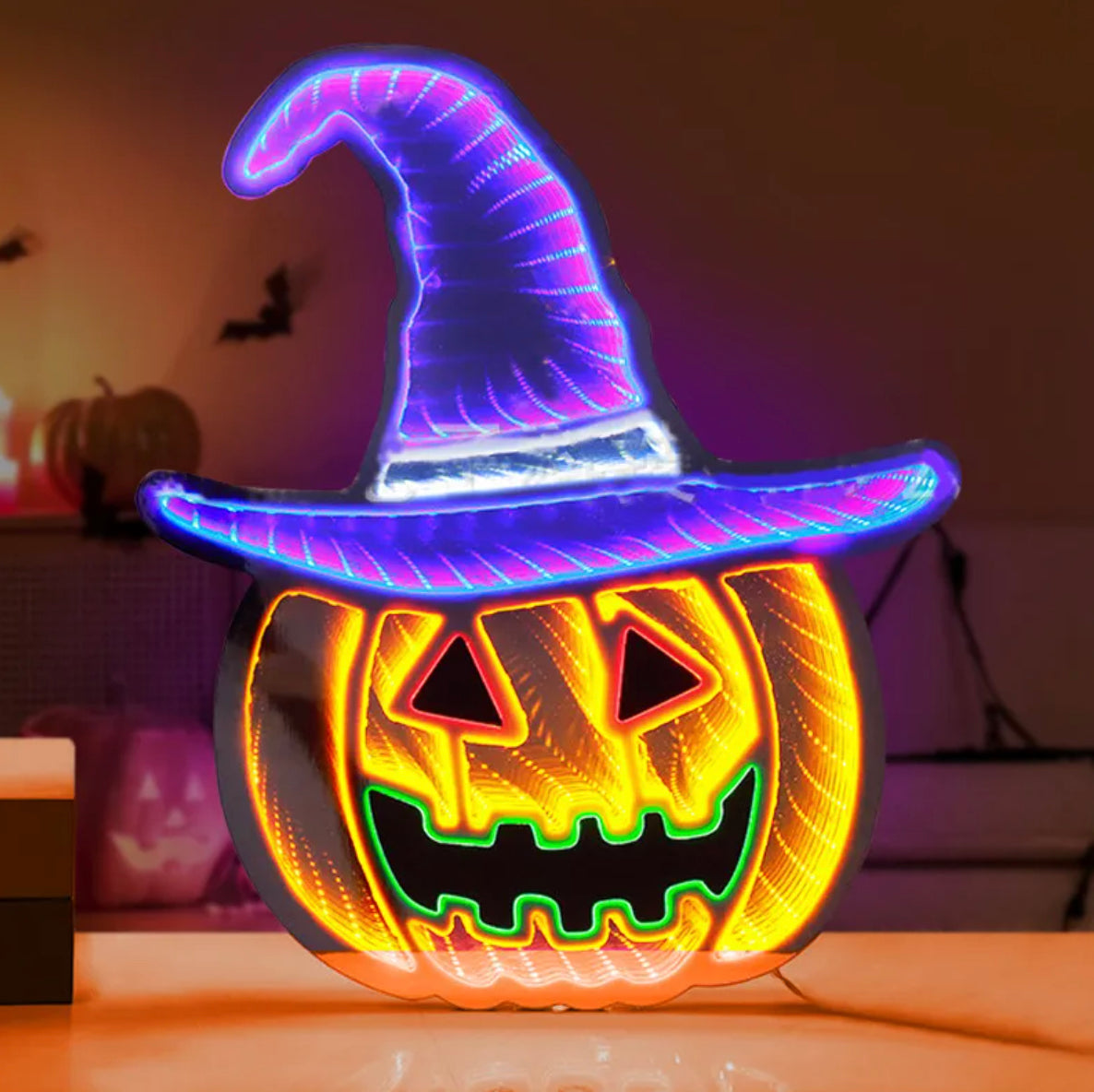 Halloween-themed light-up pumpkin with witch hat on a reflective surface.
